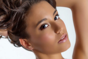 young woman with put-up hairdo is looking into camera young woman with put-up hairdo is looking into camera